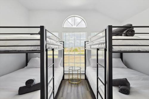 two bunk beds in a room with a window at 5BR Holiday Getaway in DeSoto with Pool, Hot Tub & Cinema in DeSoto