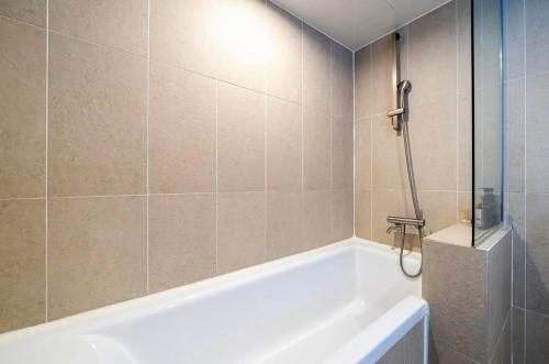 a bathroom with a white tub and a shower at Hotel Laglas Asan in Asan