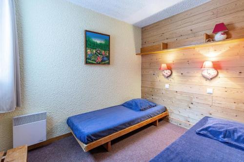 - une chambre avec 2 lits et un mur en bois dans l'établissement Résidence Lauzes G - LAUZES 45 MAE-4861, à Valmorel