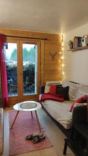 a living room with a couch and a table at Petit cocon proche Saint Gervais in Saint-Gervais-les-Bains