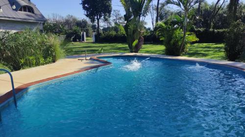 a large swimming pool with blue water in a yard at " Casa quinta "San Bernardo" Con Pileta y amplio jardín in Posadas