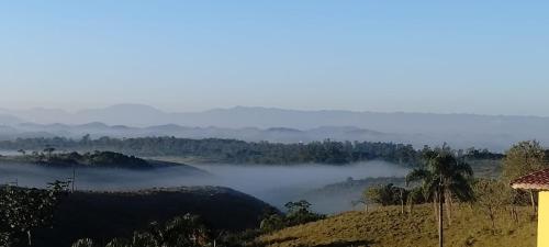 a view of a foggy valley with trees and hills at Hospedagem Encantos da Serra in Itatiaia