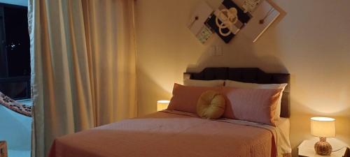 a bedroom with a bed with two lamps and a window at Hospedagem Encantos da Serra in Itatiaia