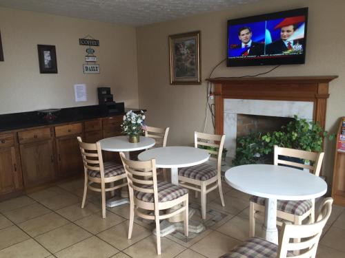 a dining room with two tables and chairs and a tv at Parkway Inn in Morristown