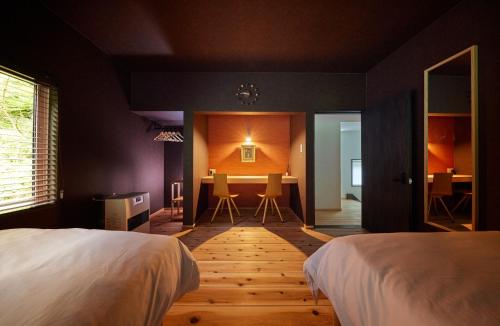 a bedroom with a bed and a table with chairs at Okuaga Totonoi-no-Yado VILLA IGASHIMA - Vacation STAY 87919v in Aga