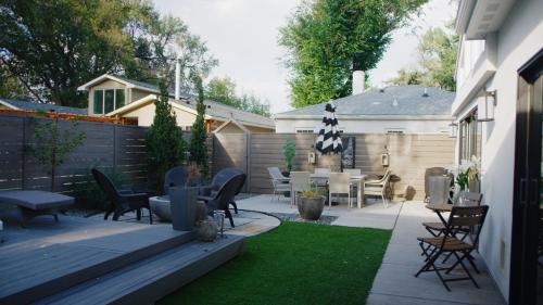 une arrière-cour avec une terrasse dotée d'une table et de chaises dans l'établissement Boutique Villa with hot tub, à Broadmoor