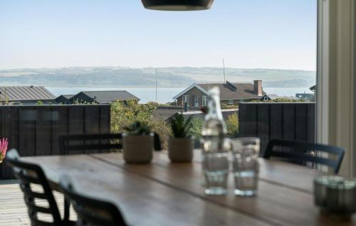 a wooden table with chairs and a view of the ocean at Cozy Home In Lemvig With Wifi in Lemvig