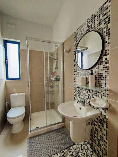 a bathroom with a toilet and a sink and a shower at TheStay Gozo in Mġarr