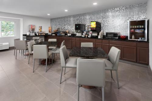 a restaurant with tables and chairs and a counter at Microtel Inn by Wyndham Janesville in Janesville