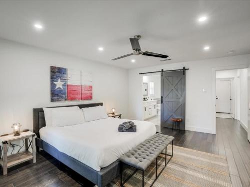 a bedroom with a large white bed and a bench at Modern Luxury Home Pool Oasis & Backyard Retreat in Plano