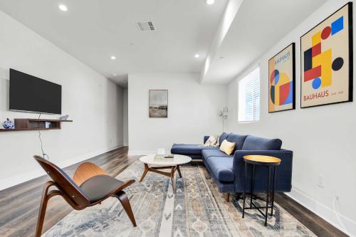 a living room with a blue couch and a tv at Spectacular Rooftop View House in Los Angeles
