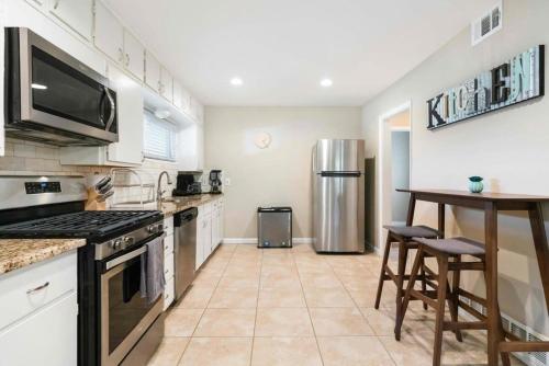 a kitchen with a table and a refrigerator at Spacious Luxurious House Big Groups and Pool in Irving
