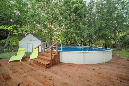 a pool on a deck with two chairs and a staircase at Spacious Luxurious House Big Groups and Pool in Irving