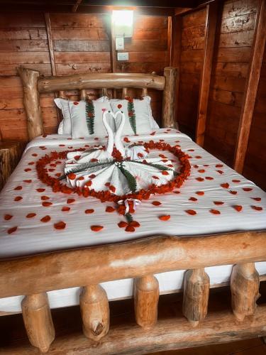a bed in a cabin with a heart made out at Glamping La Kumbre T con vista a las montañas in Gama
