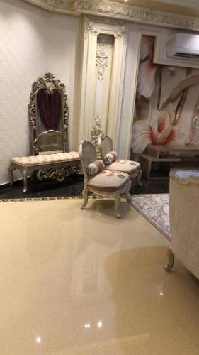 a living room with a chair and a mirror at Luxury 2BH with full Cairo Nile view in Cairo