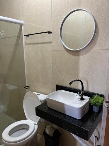 a bathroom with a sink and a toilet and a mirror at Rosendo Maia n 19 Bairro Brasiliana in Arapiraca