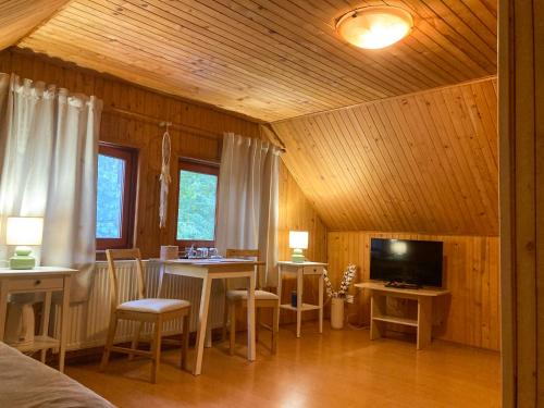 a living room with a dining room table and a television at Zlatý páv in Moldava nad Bodvou