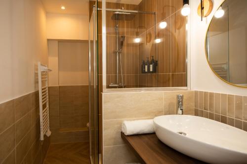 une salle de bain avec un lavabo et une douche dans l'établissement Le Zénith - Central à Dax, à Dax