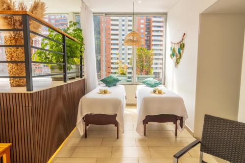 two tables in a restaurant with a window at Biohotel Organic Suites in Bogotá