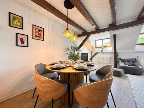a dining room with a wooden table and chairs at YourFavoriteBed Designerapartments Zwickau Zentrum in Zwickau