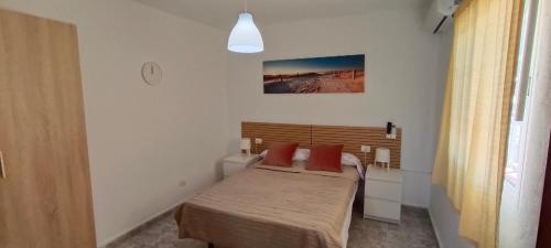 a small bedroom with a bed with red pillows at La Estancia en La Frontera El Hierro in Frontera
