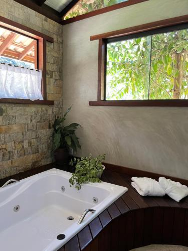 a bath tub in a bathroom with a window at Matha Pousada e Bistrô in Lumiar