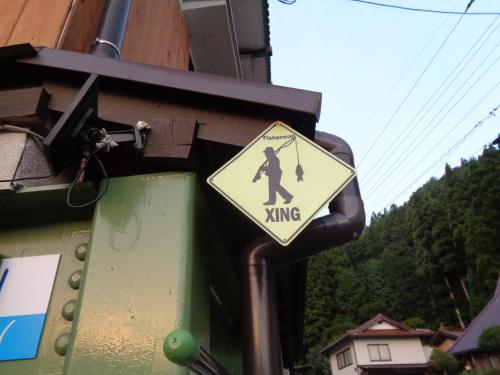 a yellow crossing sign on the side of a building at Premium Guest House Alaskan Dream in Akiota
