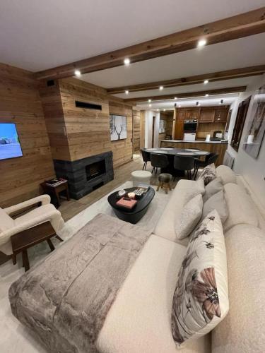 ムジェーヴにあるAppartement chaleureux à Megève - 80 m² avec jardin et cheminée.のリビングルーム(大きなソファ、ピアノ付)