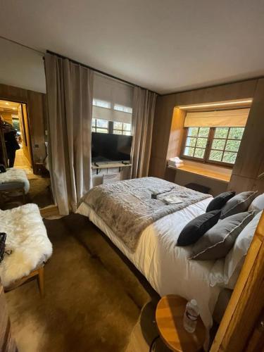 ムジェーヴにあるAppartement chaleureux à Megève - 80 m² avec jardin et cheminée.の大きなベッドと窓のある寝室