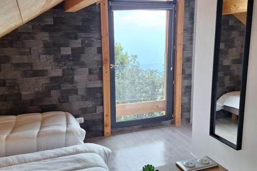 a living room with a couch and a large window at Chalet 10p sauna spa superbe vue in LʼHuez