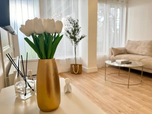 - un vase avec des fleurs blanches sur une table dans le salon dans l'établissement L'Olivier - Netflix - Bureau - Proche centre Troyes, à Troyes