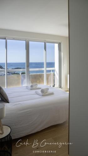 une chambre avec un grand lit avec vue sur l'océan dans l'établissement LE BELVEDERE - Appartement pleine vue mer 6 pers Concarneau, à Concarneau