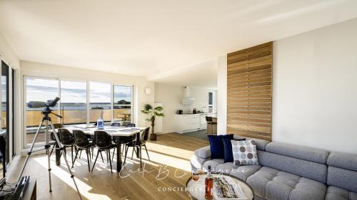 un salon avec un canapé et une table dans l'établissement LE BELVEDERE - Appartement pleine vue mer 6 pers Concarneau, à Concarneau