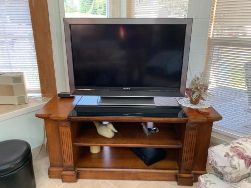 a flat screen tv on a wooden table in a living room at Lake Tapps Bungalow in Dieringer