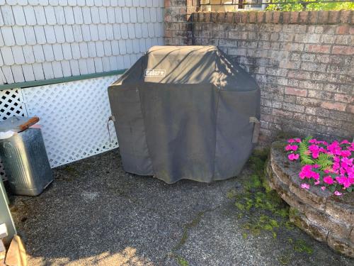 a large dumpster sitting next to some pink flowers at Lake Tapps Bungalow in Dieringer