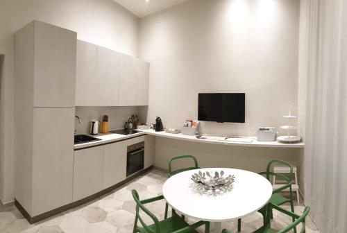 a kitchen with a white table and a table and chairs at Appartamento Pertinace Centro Storico Alba in Alba