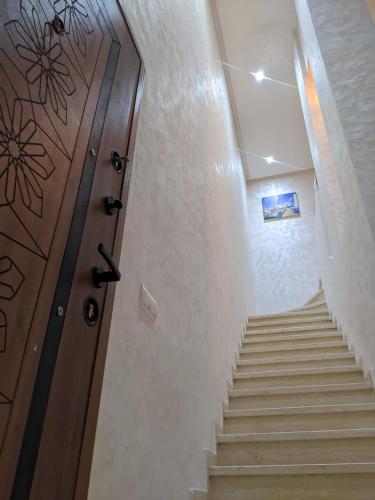 a hallway with a wooden door and stairs at Janat House in Marrakech