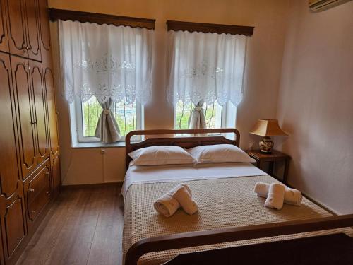 a bedroom with a bed with two towels on it at Amalia's House in Gjirokastër