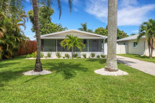 a house with palm trees in the yard at Little Beach House w/ POOL&SPA - 5 minutes to Vanderbilt Beach (Pet Friendly) in Naples