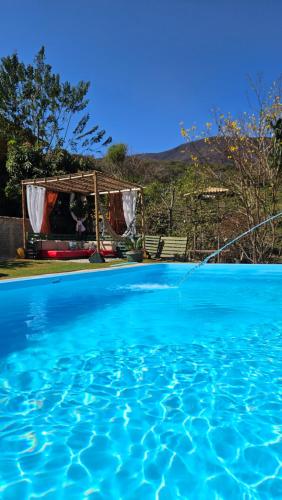Elle offre une vue sur la piscine et le kiosque. dans l'établissement Espaço Villa Pella - Chalé Peônia, à Brumadinho