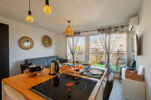 una cocina y una sala de estar con una mesa con comida. en T2 - Terrasse - 3 min à pieds des plages- Parking privée - Clim - Wifi - 4 PAX, en La Grande-Motte