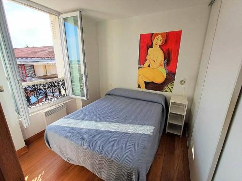 Un dormitorio con una cama y un cuadro en la pared. en Bonito estudio reformado 1 dormitorio 3 personas, en Hendaya