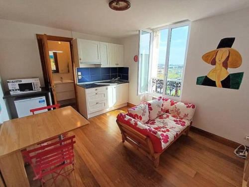 un salon avec un canapé et une table dans l'établissement Bonito estudio reformado 1 dormitorio 3 personas, à Hendaye