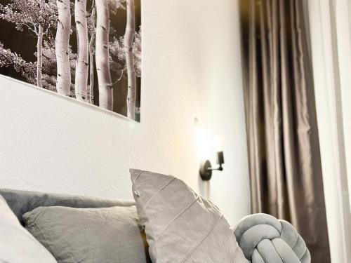 a living room with a couch and a picture of trees at modern living in Karlsruhe - frieden apartments in Karlsruhe