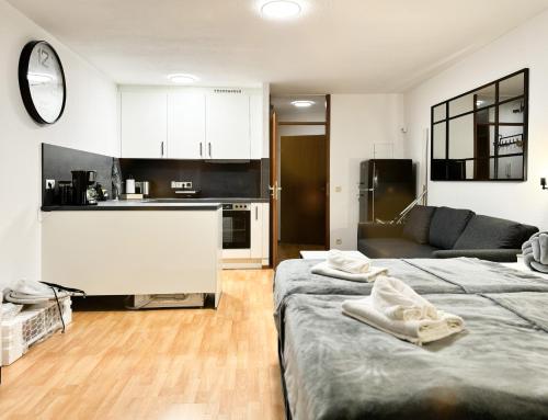 a living room with two beds and a kitchen at modern living in Karlsruhe - frieden apartments in Karlsruhe