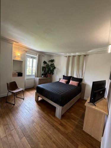 une chambre avec un lit et une chaise dedans dans l'établissement Au Cœur de la Nature, idéalement placé Paris, à Presles