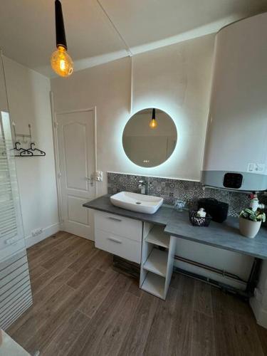 une salle de bain avec un lavabo et un miroir dans l'établissement Au Cœur de la Nature, idéalement placé Paris, à Presles