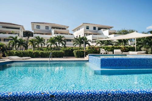 a swimming pool in front of some apartment buildings at Seabreeze Retreat Stylish Blue Bay Residence in Sint Michiel