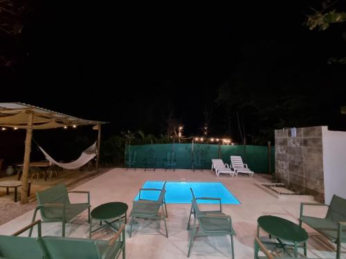 a group of chairs and a swimming pool at night at Pinilla Highlands Incredible mountain views in Tamarindo