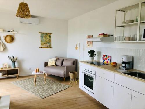 une cuisine et un salon avec un canapé dans l'établissement Lou Pitchou, le T1, à La Ciotat
